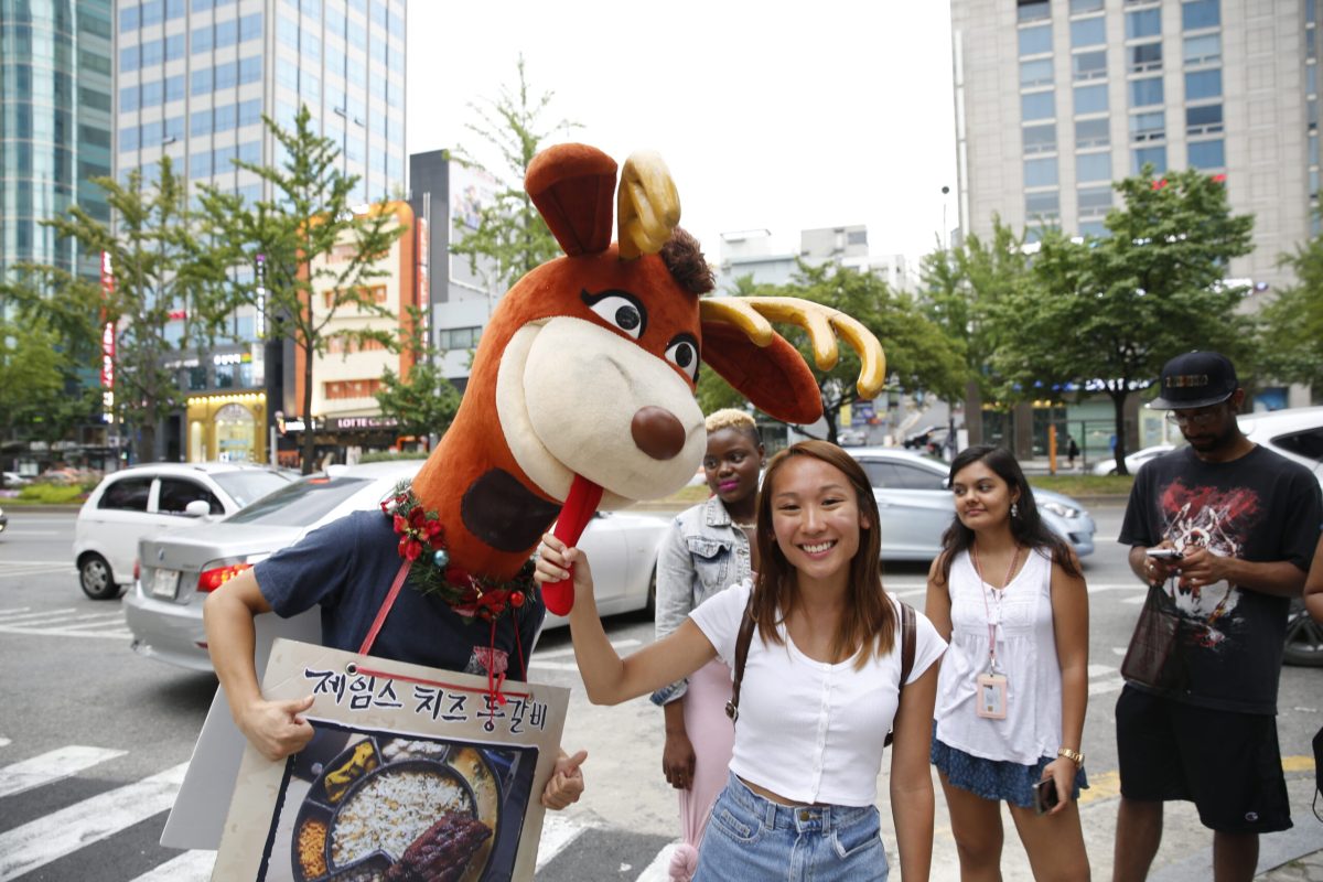 Student posing with a mascot