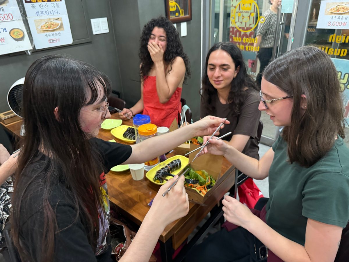 A student teaching another student how to use chopsticks