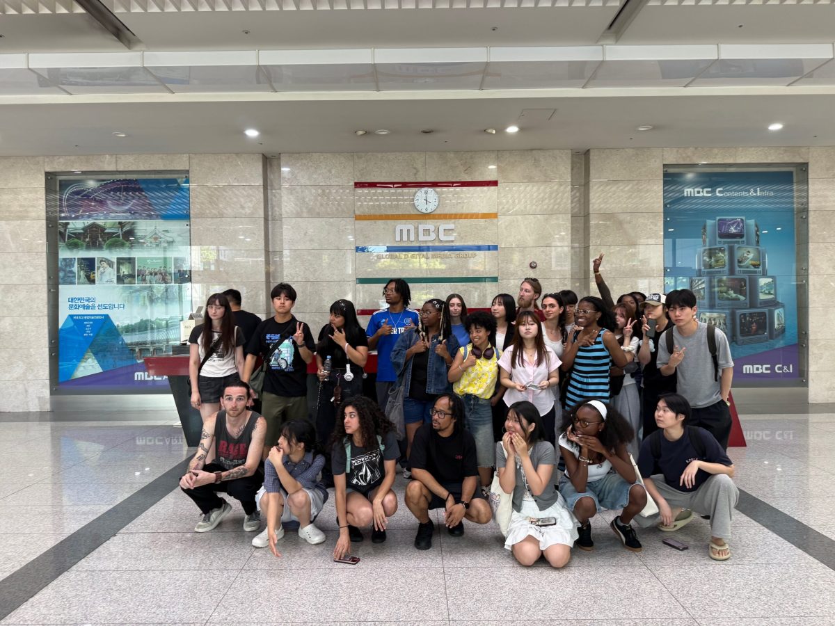 Students taking photo a front of the MBC sign