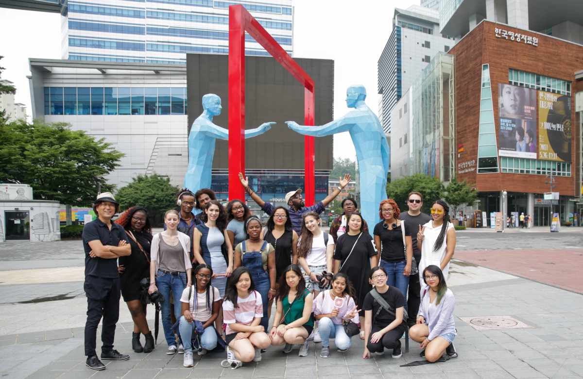 Students standing a front of a art structure 